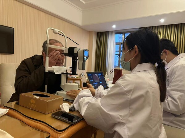 图:云鹊医工作人员为老人做眼底照相检查